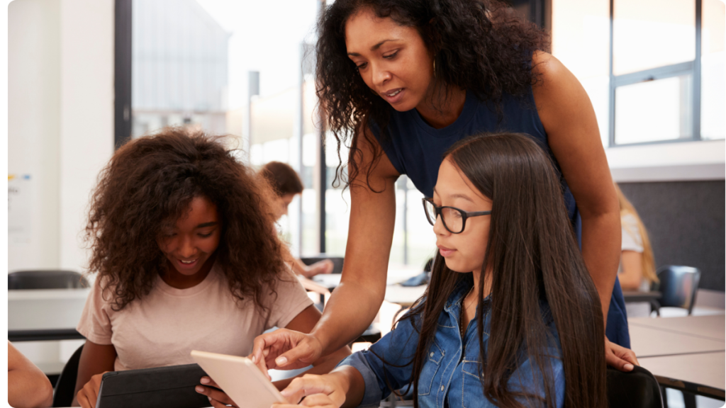 teacher helping students with online schoolwork.